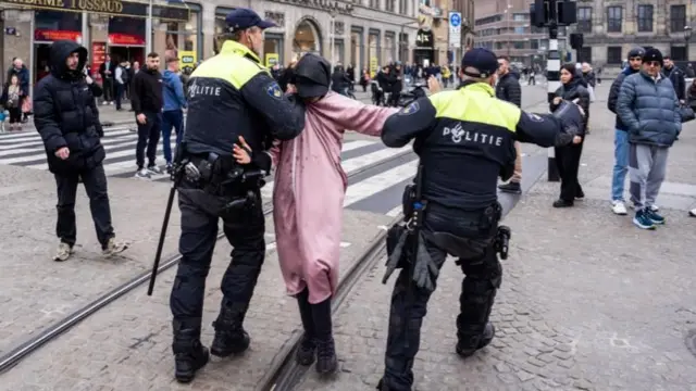 एक व्यक्ति को हिरासत में लेती नीदरलैंड पुलिस