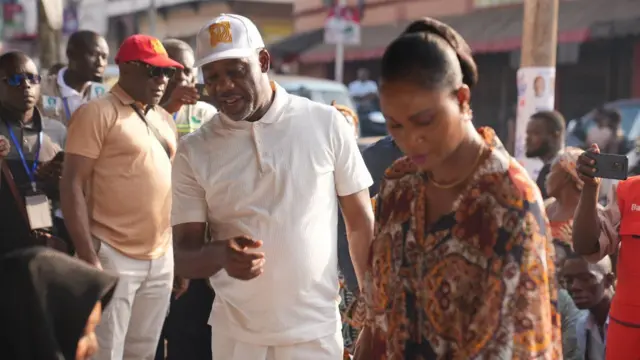 Vice presidential candidate of NPP on white shirt wit a woman