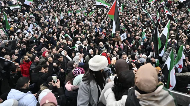 الأعلام الفلسطينية وأعلام المعارضة السورية في حشد احتفالي بسقوط حكم الأسد وسط ستوكهولم في السويد