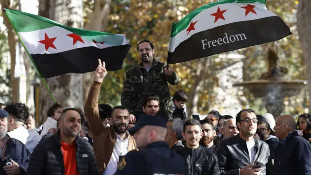 أنصار المعارضة السورية المقيمون في إسبانيا يلوحون بأعلام المعارضة السورية في العاصمة مدريد