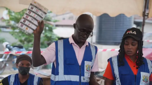 EC official holding up a ballot paper