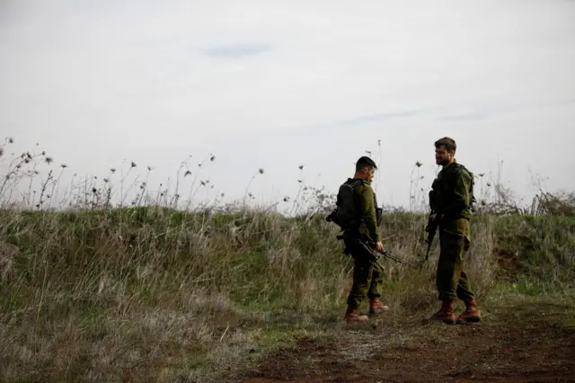 جنديان إسرائيليان يقفان كحرس قرب خط وقف إطلاق النار بين سوريا وهضبة الجولان المحتلة