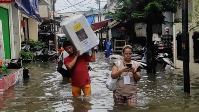 မြို့တော် ဂျာကာတာက နေရာအချို့မှာ ရေကြီးနေတာကြောင့် မဲပုံးတွေကို ရေထဲ ဖြတ်ကျော်သယ်ခဲ့ရ
