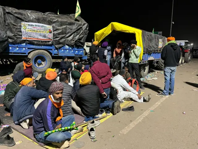 शाम को ट्रालियों के पास बैठे किसान