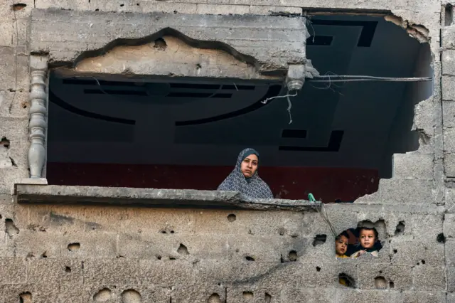 فلسطينية تقف في منزل تعرض للقصف