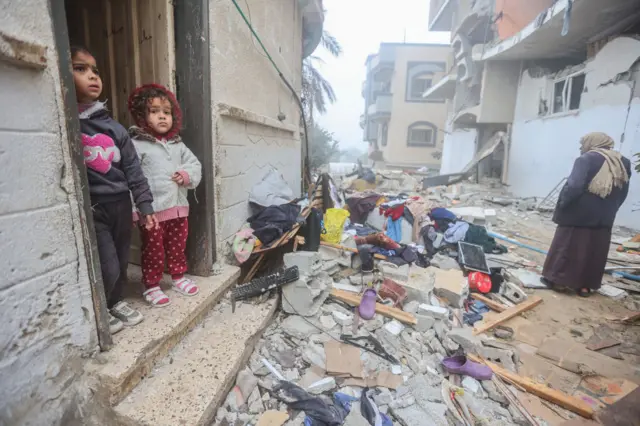 أطفال يفقون وسط حطام أبنية في رفح.