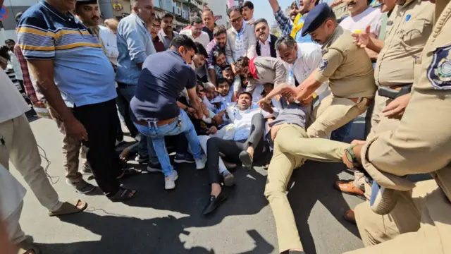 दिल्ली सरकार की नई आबकारी नीति में कथित अनियमितता के मामले में गुरुवार रात दिल्ली के मुख्यमंत्री अरविंद केजरीवाल को ईडी ने गिरफ़्तार किया, जिसके बाद से देश के कई शहरों में पार्टी कार्यकर्ता प्रदर्शन कर रहे हैं. यह तस्वीर गुजरात की है.