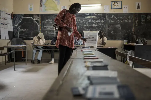 Une électrice choisit son bulletin