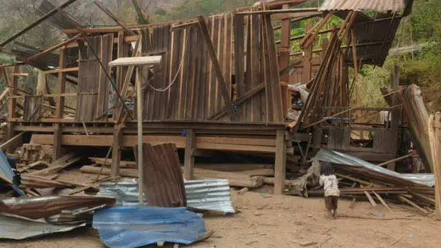 မင်းတပ်မြို့နယ် တိုက်နယ် ၃အတွင်း မတ်လ ၁၅ ရက် လေကြောင်းတိုက်ခိုက်မှုကြောင့် ပျက်စီးသွားတဲ့အိမ်နားမှာ ရပ်နေတဲ့ ကလေးငယ်