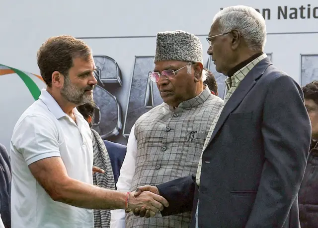 राहुल गांधी, डी राजा से हाथ मिलाते हुए. बीच में हैं कांग्रेस अध्यक्ष मल्लिकार्जुन खड़गे.