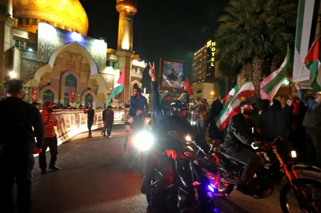 إيرانيون يلوحون بعلم إيران وعلم فلسطين احتفاء بالضربة الإيرانية ضد إسرائيل