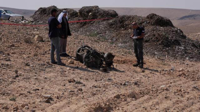 ضابط شرطة وسكان يتفقدون بقايا صاروخ معزز، وفقًا للسلطات الإسرائيلية، أصاب فتاة تبلغ من العمر 7 سنوات بجروح خطيرة، بعد أن أطلقت إيران طائرات بدون طيار وصواريخ باتجاه إسرائيل، بالقرب من أراد، إسرائيل، 14 أبريل، 2024. رويترز / كريستوف فان دير بير