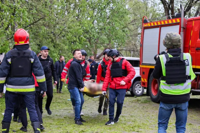 Спасатели несут раненого