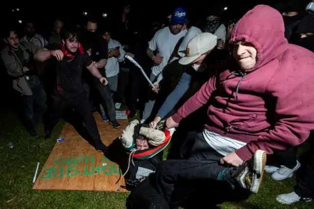 A pro-Palestinian demonstrator is surrounded by counter-protesters