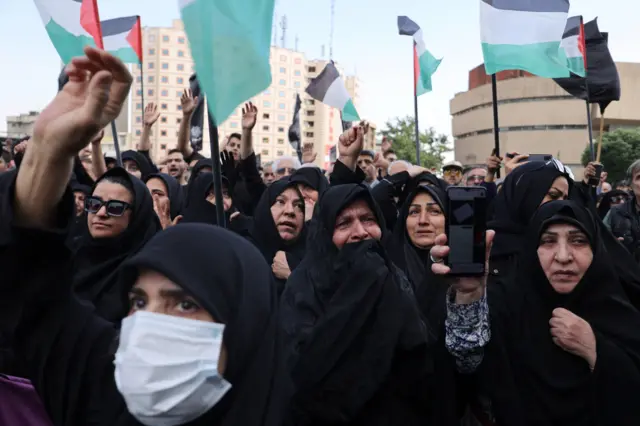 نساء إيرانيات يبكين تبكي بينما يتجمع الناس حدادًا على وفاة الرئيس الإيراني الراحل إبراهيم رئيسي في طهران