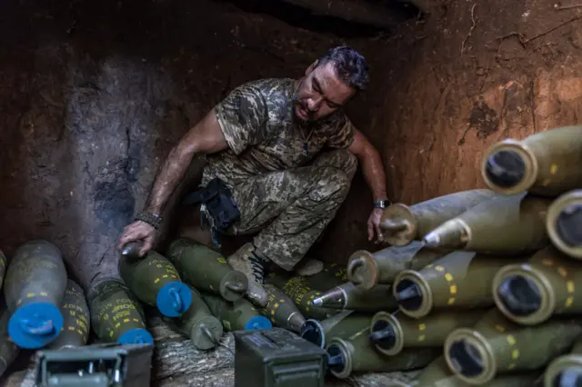 Украинский солдат на боевой позиции в Донецкой области готовит 155-мм снаряды