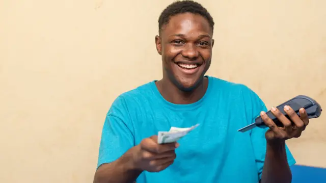 Nwata nwoke ji akwụkwọ ego na igwe POS