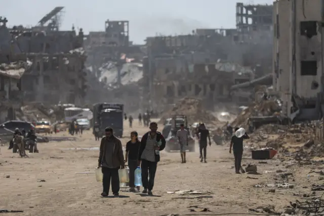 فلسطينيون نازحون داخليًا يسيرون بعد عودتهم إلى خان يونس