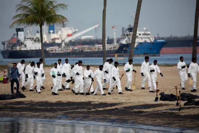 ကမ်းခြေမှာ ရှင်းလင်းရေးလုပ်နေကြသူတွေ