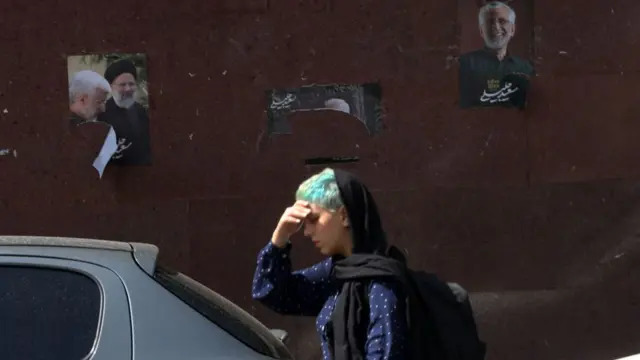 زنی در برابر پوستر انتخاباتی