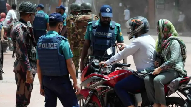 কারফিউর মধ্যে মোটরসাইকেল নিয়ে বের হওয়ায় জিজ্ঞাসাবাদ করছেন পুলিশ সদস্যরা