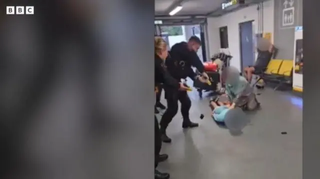 मैनचेस्टर हवाई अड्डे पर टेजर गन ताने हुए पुलिसकर्मी