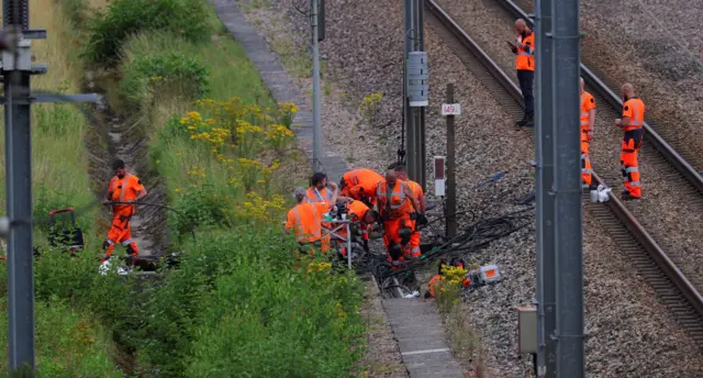 फ्रांस में रेल के सिग्नल डिब्बे को दुरुस्त करते एसएनसीएफ़ के कर्मचारी