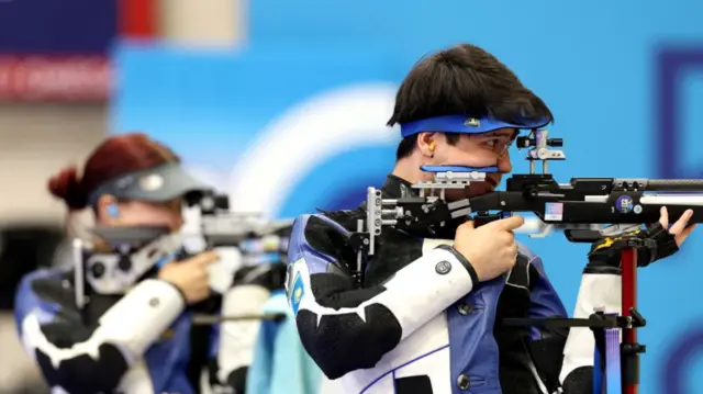 पेरिस ओलंपिक में शूटिंग इवेंट में भाग लेते खिलाड़ी