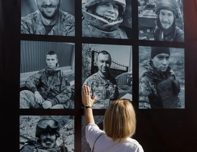 Женщина у фотографий военнопленных