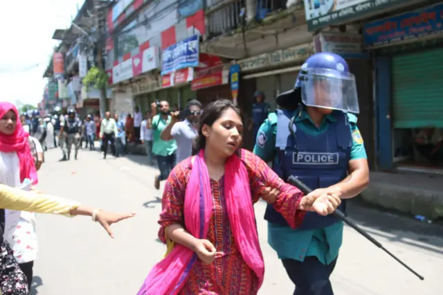 একজন বিক্ষোভকারীকে আটক করে নিয়ে যাচ্ছে পুলিশ
