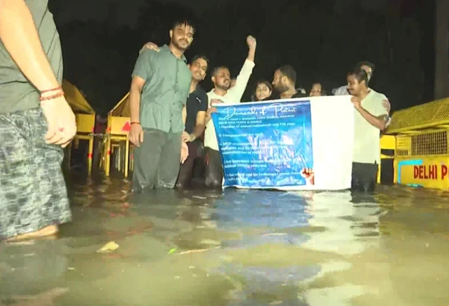 दिल्ली के राजेंद्र नगर में बारिश के दौरान प्रदर्शन करते छात्र