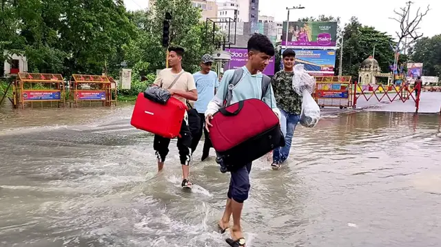 वडोदरा में विश्वामित्री नदी के उफान पर होने के कारण घर में पानी घुसने के बाद लोग सुरक्षित स्थानों पर जा रहे हैं.