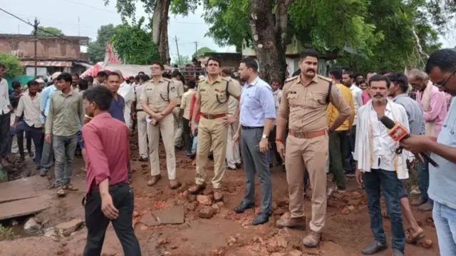 दीवार गिरने के बाद मौके़ पर मौजूद पुलिसकर्मी