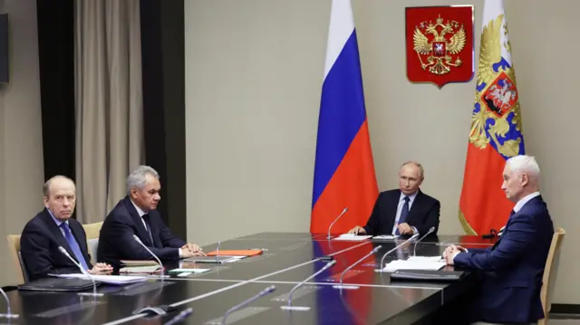 Президент России Владимир Путин сидит за столом с секретарем Совета безопасности РФ Сергеем Шойгу, директором ФСБ Александром Бортниковым, министром обороны Андреем Белоусовым