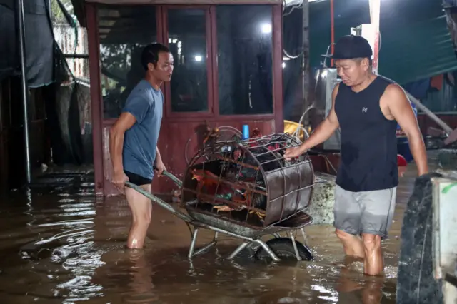 Trong ảnh là hai người dân Hà Nội chở gà chạy lũ vào hôm nay 10/9.