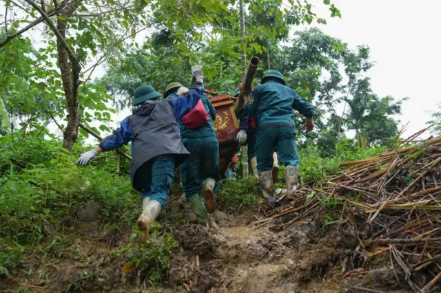 Khiêng nạn nhân chết trong thảm họa lũ quét