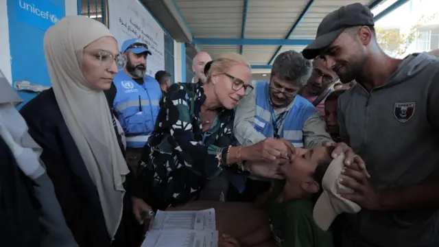 ग़ज़ा में बच्चे को दवा पिलातीं यूएन की अधिकारी सेग्रिड काग