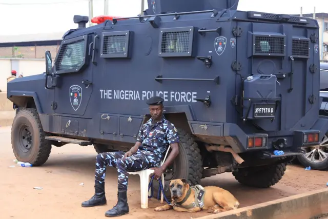 One policeman sit down hold dog and rest im back for one police van
