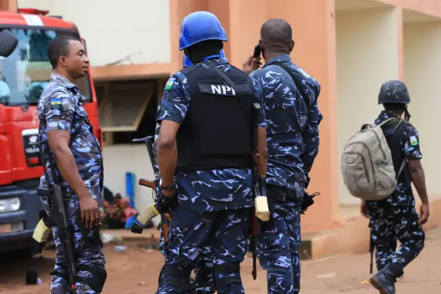 Four armed policemen stand