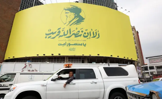 لافتة في إيران عليها صورة شعار حزب الله والأمين العام للحزب حسن نصر الله