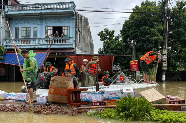 Lực lượng cứu hộ cứu nạn đưa nước và thực phẩm tới cho người dân bị kẹt do lũ