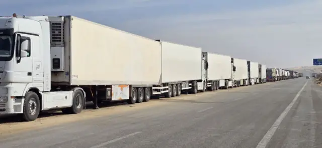 تظهر شاحنات المساعدات عند معبر رفح في الجانب المصري، بانتظار العبور إلى قطاع غزة، في 16 يناير/كانون الثاني 2025.