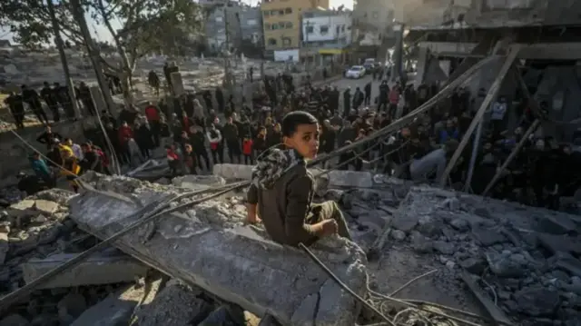طفل يجلس على أنقاض مبنى دمر بفعل ضربات إسرائيلية على قطاع غزة