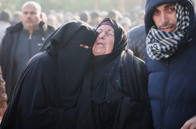 مشيعون يقفون بالقرب من جثث فلسطينيين قتلوا في غارات جوية إسرائيلية