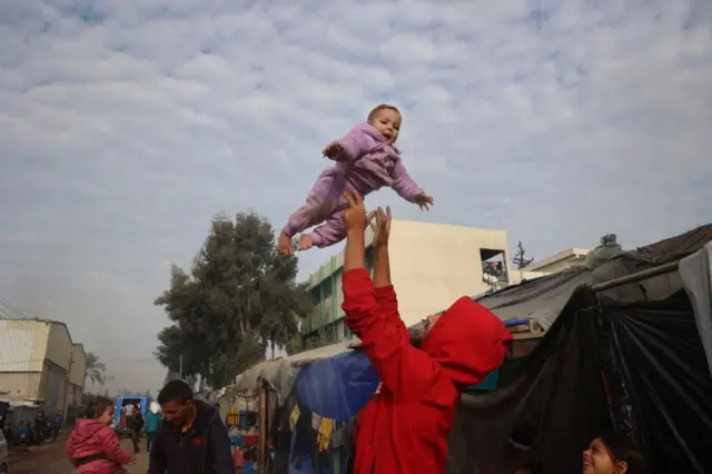 نازحون فلسطينيون خارج خيامهم في دير البلح في وسط قطاع غزة في 16 يناير/ كانون ثاني 2025