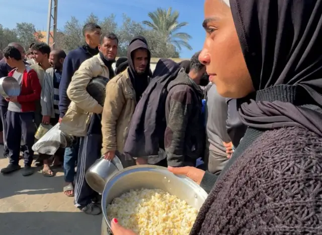 لميس محمد الميزرعي تقف في طابور للحصول على الأرز