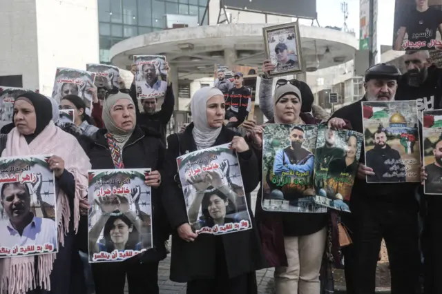 متظاهرات فلسطينيات في نابلس بالضفة الغربية المحتلة، يحملن لافتات عليها صور سجناء فلسطينيين، يطالبون بتضمينهم في اتفاق تبادل الأسرى بين حماس وإسرائيل