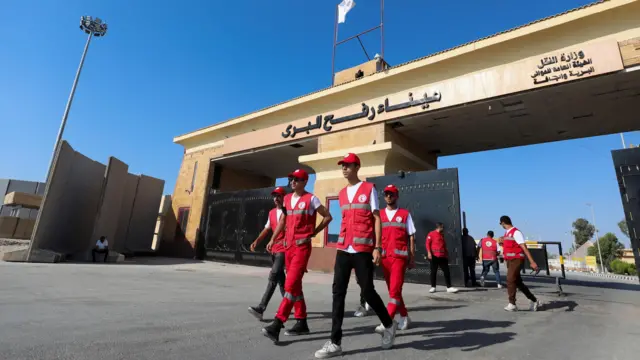 أعضاء من الهلال الأحمر يسيرون عند معبر رفح الحدودي بين مصر وقطاع غزة، في ظل الصراع المستمر بين إسرائيل وحماس، في رفح، مصر