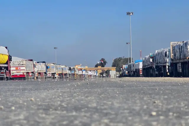 شاحنات محملة بالمساعدات الإنسانية تنتظر على الجانب المصري من معبر رفح الحدودي مع قطاع غزة في 18 يناير 2025