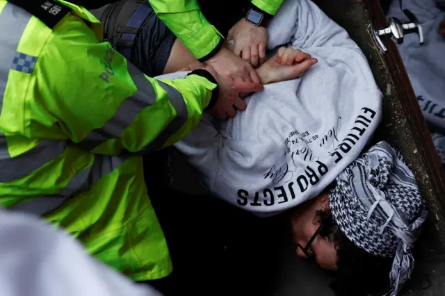 ضباط الشرطة يعتقلون متظاهرا خلال مظاهرة لدعم الفلسطينيين في غزة